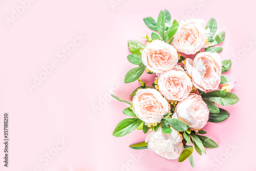 Floral peonies arrangement . Artificial tender white pinkish peony flower with leaves  flat composition on a light background. top view place for text