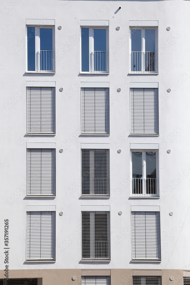 Fototapeta premium weiße Fenster mit heruntergezogenen Rolläden an einer weissen Hauswand, Bremen, Deutschland, Europa
