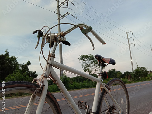 bicycles on the road and electricity poles in the evening sky