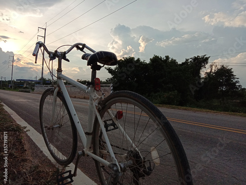 bicycles on the road and electricity poles in the evening sky