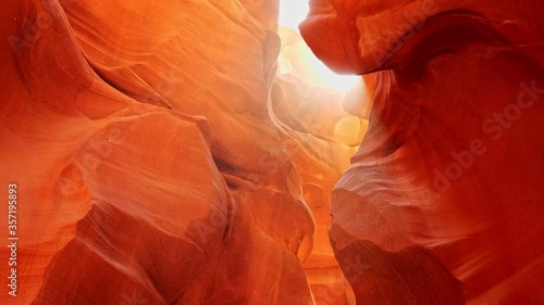 Dust flies in the sun in antelope canyon. Zoom out shot of red walls of Antelope Canyon in Arizona, USA