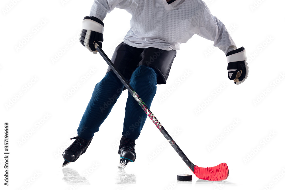 Obraz premium Unrecognizable male hockey player with the stick on ice court and white background. Sportsman wearing equipment and helmet practicing. Concept of sport, healthy lifestyle, motion, action. Close up.
