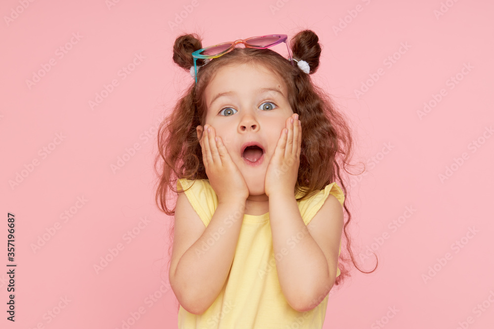 Portrait of a happy child. Cute little girl with a funny face on a pink background. Advertising baby products Portrait of a happy child. Cute little girl with a funny face on a pink background. Advertising baby products