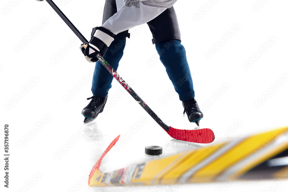 Obraz premium Unrecognizable male hockey player with the stick on ice court and white background. Sportsman wearing equipment and helmet practicing. Concept of sport, healthy lifestyle, motion, action. Close up.