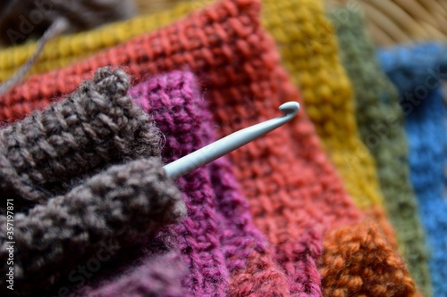Crochet wool rainbow scarf and hook photo