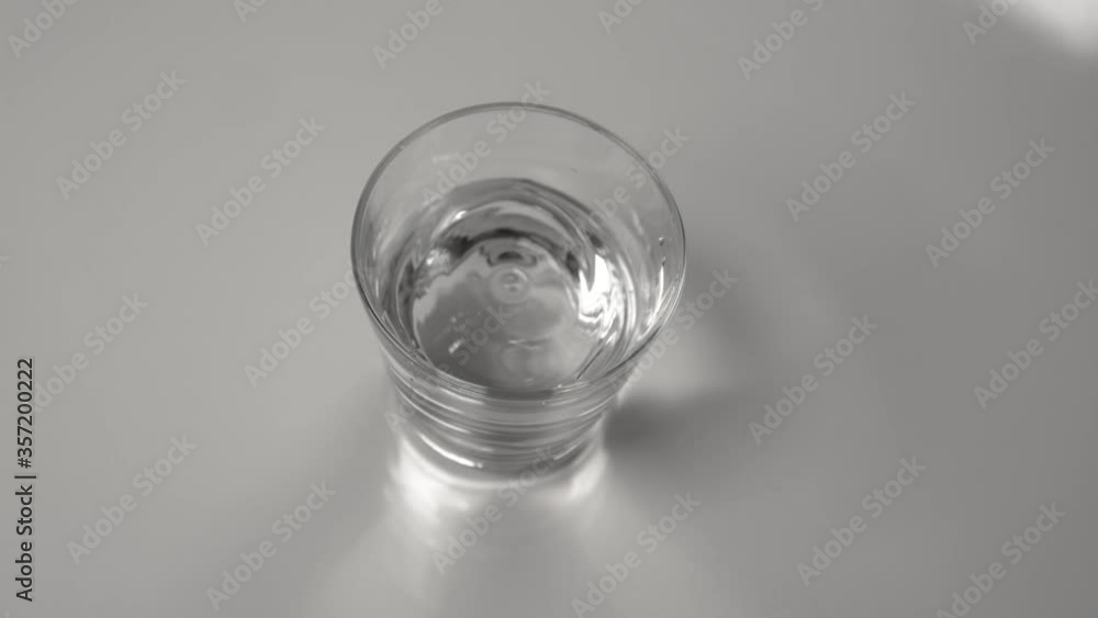 SLOW MOTION, CLOSE UP, DOF: Refreshing water inside a small transparent glass gets spilled during an earthquake. Glassy tapwater splashes inside a transparent glass during a mild seismic event. SLOW MOTION, CLOSE UP, DOF: Refreshing water inside a small transparent glass gets spilled during an earthquake. Glassy tapwater splashes inside a transparent glass during a mild seismic event.