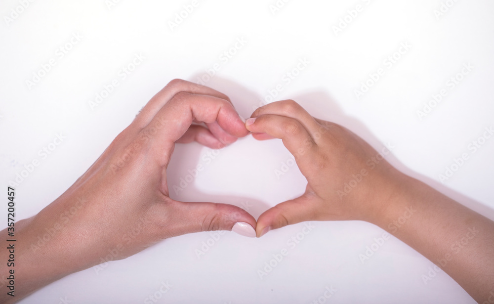 Fototapeta premium Love heart in hand. Hand of mother and child making heart shape together on white background. World humanitarian day concept.