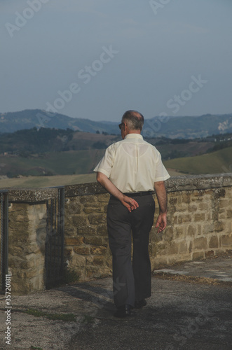 A statuesque man walks through a castle in Italy, Bertinoro photo