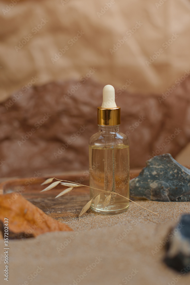 Bottle with a pipette, filled with essence, oil or perfume. Background sand and craft paper. Bottle with a pipette, filled with essence, oil or perfume. Background sand and craft paper.