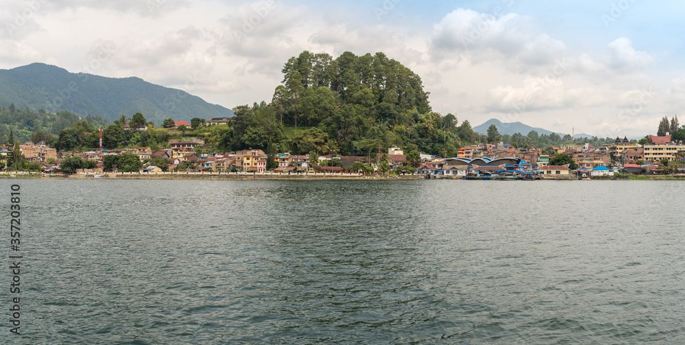 The small town Parapat with its ferry port Tiger Raja at the lakeshore of the famous Lake Toba, the largest volcanic lake in the world. The town is the ferry harbor to the island of Samosir