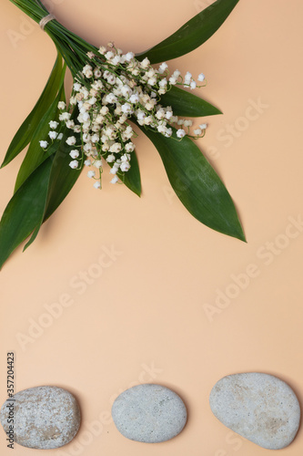 Fotografie Bouquet of lilies of the valley, still life on an orange background