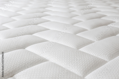 Close up shot of white orthopedic mattress top side surface pattern with a lot of copy space for text. Hypoallergenic foam matress for proper spinal alingment and pressure point relief. Background. photo