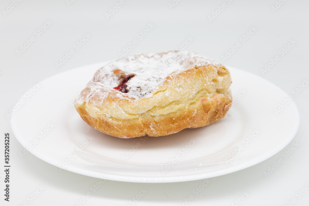 Powdered Jelly Donut on a White Plate with a White Background Powdered Jelly Donut on a White Plate with a White Background