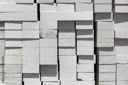 Aerated concrete blocks of light building material of white color piled on a pile for construction, texture closeup nobody. photo