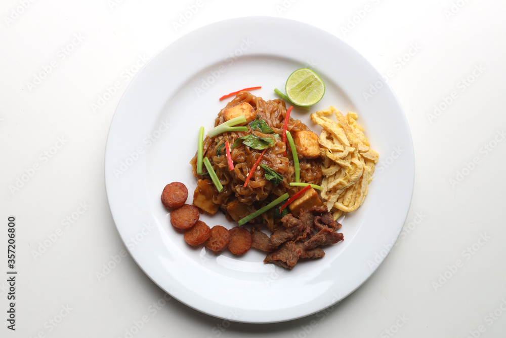 Closeup Pad Mee Korat (Stir-Fried Noodle Thai Korat style) served on a white plate Put on the white table Ready to eat Taken from above Closeup Pad Mee Korat (Stir-Fried Noodle Thai Korat style) served on a white plate Put on the white table Ready to eat Taken from above