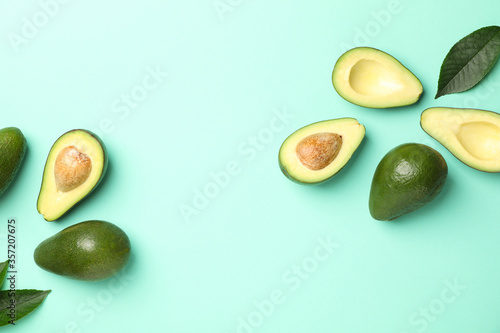 Ripe fresh avocado on mint background, space for text