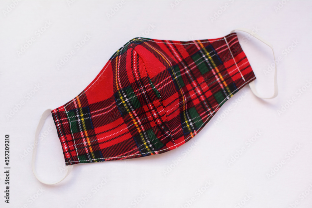 Red plaid cloth protective mask, isolated on white background. Covid-19 pandemic protection. Red plaid cloth protective mask, isolated on white background. Covid-19 pandemic protection.