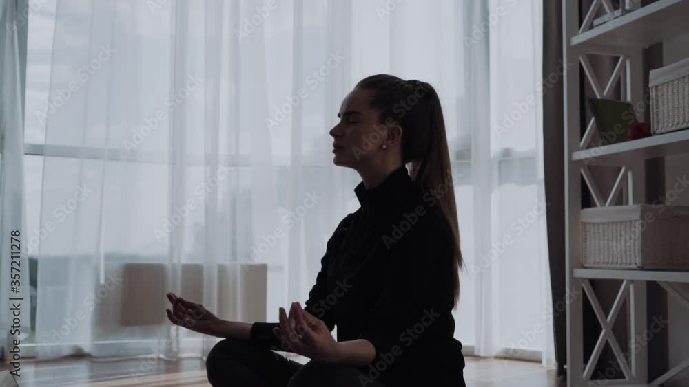silhouette of woman sits in staff easy lotus pose at home , meditating alone yoga training, doing breathing exercise in the morning, no stress silhouette of woman sits in staff easy lotus pose at home , meditating alone yoga training, doing breathing exercise in the morning, no stress