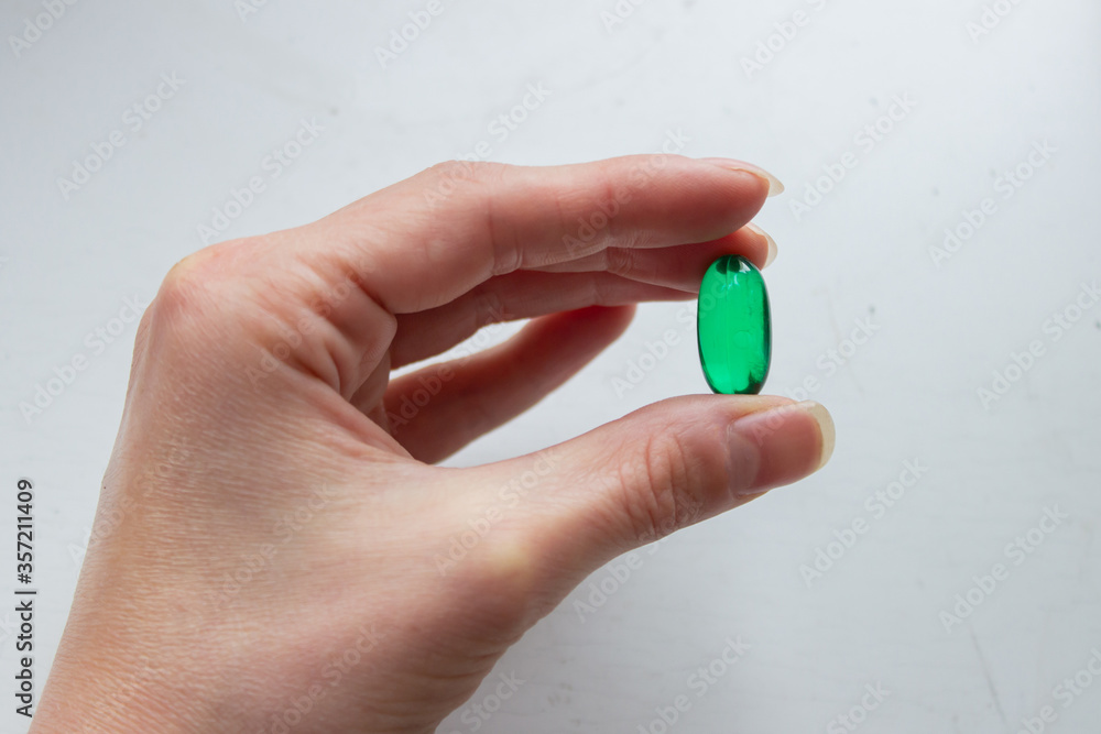 green pill in the hand on white background, green pill in the hand on white background,