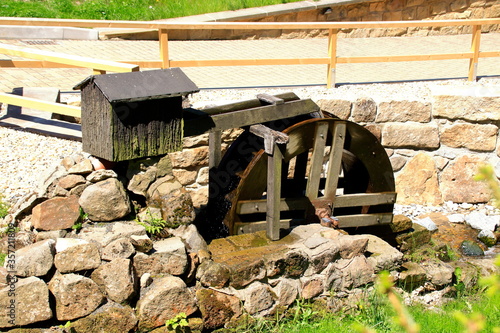 Kleines mühlrad in einem wasserlauf photo