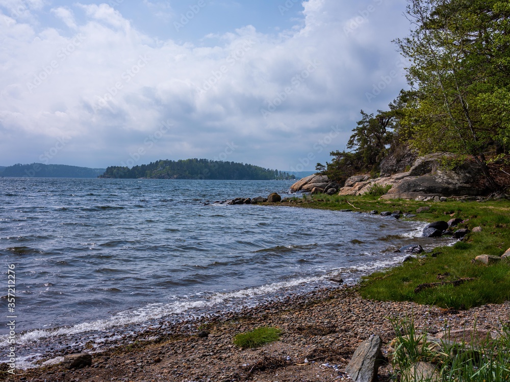 Shore with pebbles and grass in Sweden Shore with pebbles and grass in Sweden