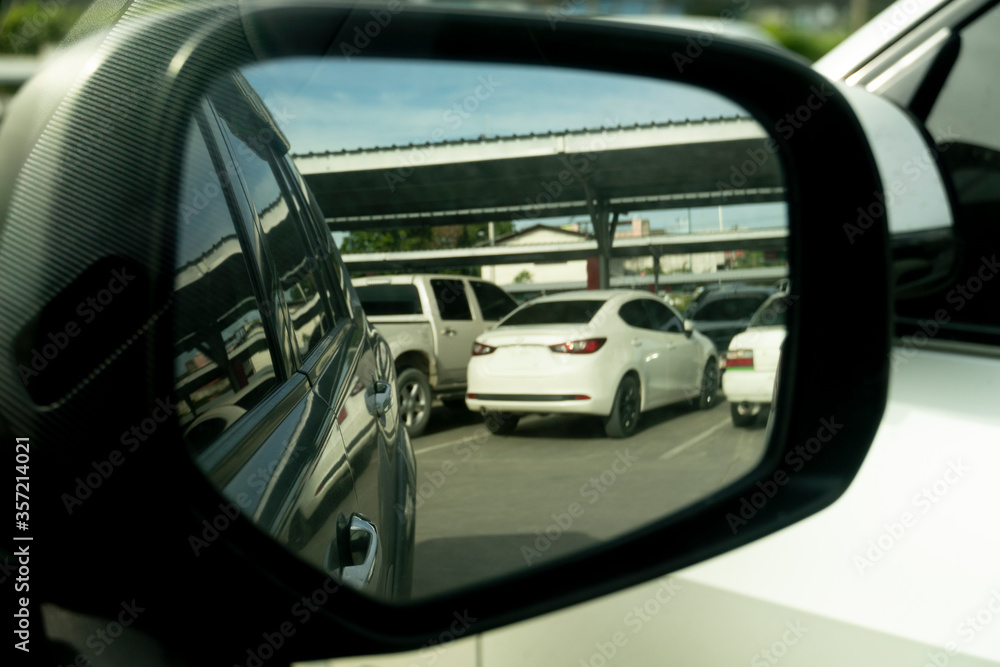 Abstract wing mirror view of car. Looking cars in parking lot.