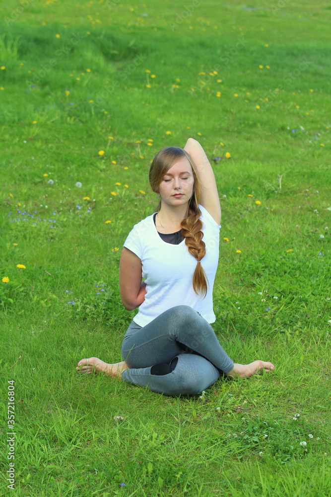 Young woman of European appearance does yoga in summer nature Young woman of European appearance does yoga in summer nature