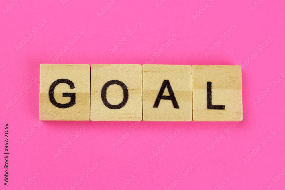 Goal word of wooden letters on a pink background Goal word of wooden letters on a pink background
