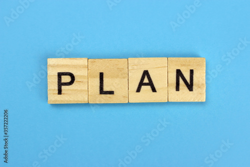 Plan word of wooden letters on a blue background