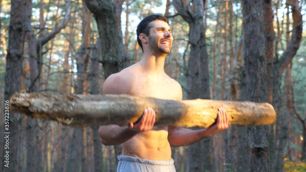 Close up muscular body of man lifting hard weight training biceps. Strong guy working out outdoor. Athlete exercising in nature using log. Concept of sport and active lifestyle. Slow motion Close up Close up muscular body of man lifting hard weight training biceps. Strong guy working out outdoor. Athlete exercising in nature using log. Concept of sport and active lifestyle. Slow motion Close up