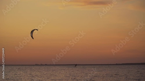 Beautiful sunset in the sea. Kite surfers ride on the sea. 4K