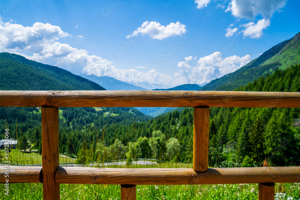 Wooden vintage fence and blurred background of nature mountain's meadow landscape background with sunny day. Travel and holidays.