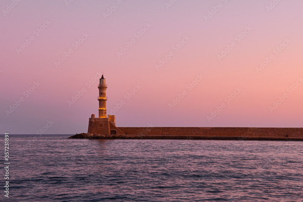old lighthouse of xania in red dawn and calm mediterranean sea