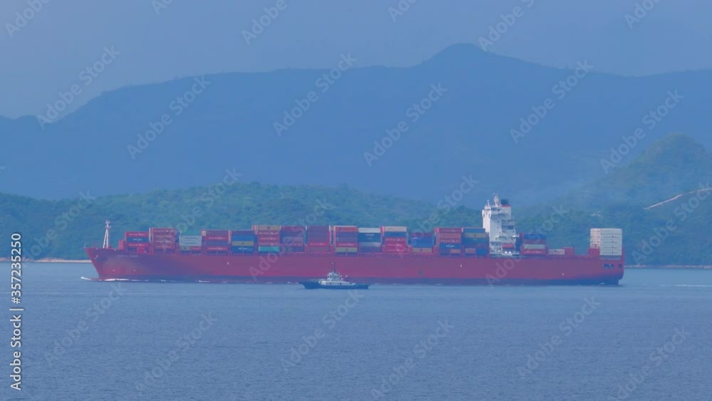 Large Container Ship sailing in still waters in the morning under blue sky. 4K Red Freighter Large Container Ship sailing in still waters in the morning under blue sky. 4K Red Freighter