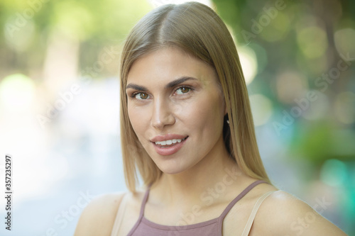 Portrait of young happy smiling woman outdoor on street.