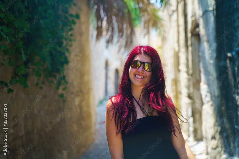 Fototapeta premium Happy woman traveler is walking and exploring Greek island of Rhodes, Dodecanese, Greece