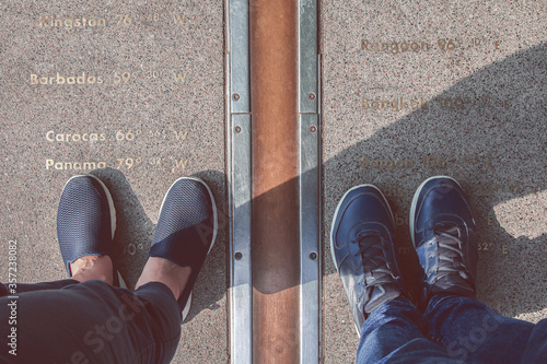 Tableau sur toile Pairs of legs stand on either side of the Prime Meridian