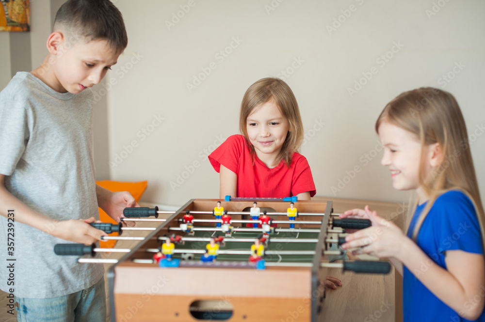 Fototapeta premium Children play table football. Games in the children's room.