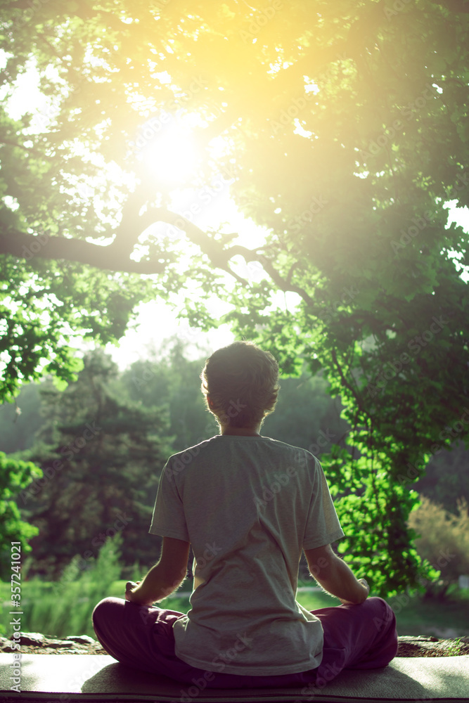Red-haired male Buddhist meditates on a background of nature Red-haired male Buddhist meditates on a background of nature