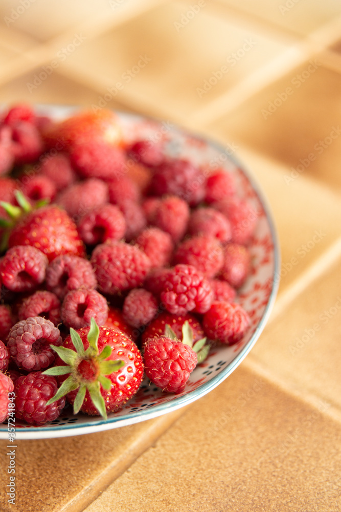 Assiette de fraises et de framboises fraîches dans une cuisine Assiette de fraises et de framboises fraîches dans une cuisine