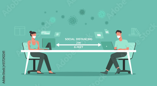 man and woman working in the office together maintain social distancing to prevent spreading of Covid-19 or Coronavirus