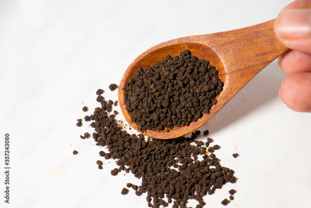Dried Tea Leaves powder on Spoon With White Background Dried Tea Leaves powder on Spoon With White Background