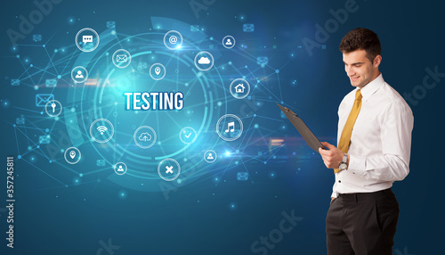 Businessman thinking in front of technology related icons and TESTING inscription, modern technology concept