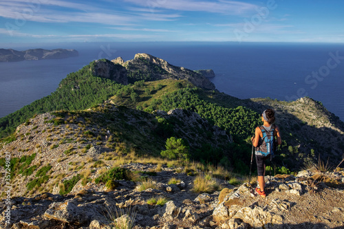 escursionista observando Penya Roja -Penya des Migdia-, área natural de la Victòria, Alcúdia,  Mallorca, balearic islands, Spain photo