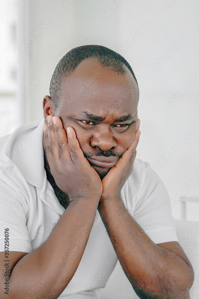 Fototapeta premium Loss of a loved one. Grief in the family. Death of a child. Sad face depressed elderly african man. Very sad elderly man. Concept of loneliness and pain.