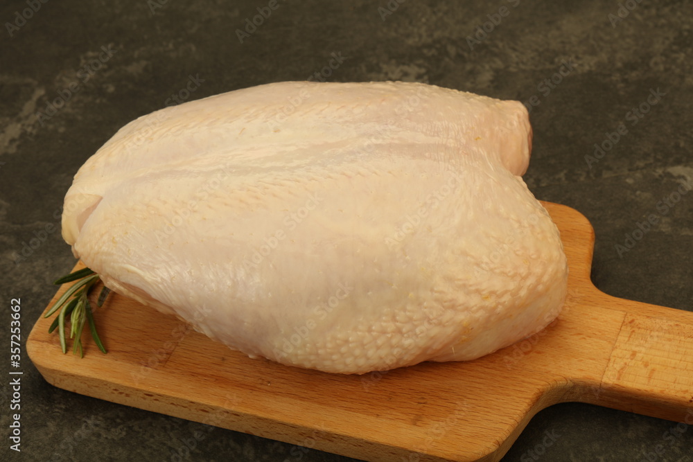 Raw whole chicken breast with skin