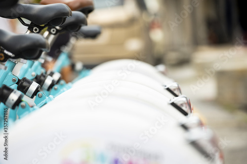 (Selective focus) Bicycle sharing system with some blurred bikes parked in George Town, Penang, Malaysia. The Bicycle sharing system is a service in which bicycles are made available for shared use.