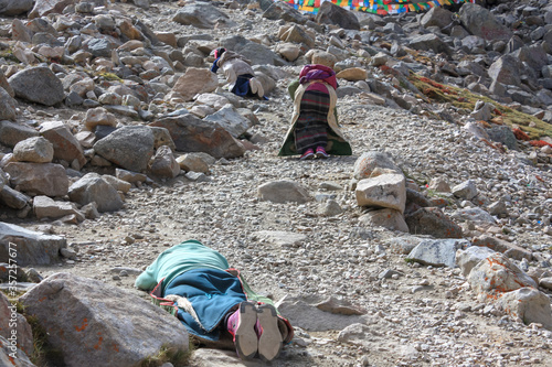 Pilgrims prostrating on stony trekking kora around mountain Kailash pilgrimage route near Darchen, Tibet, Asia
