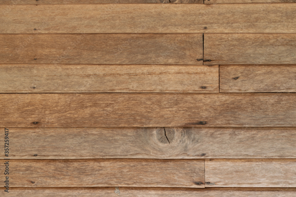 Obraz premium Close-up horizontal stripes of wood plank brown texture background with seam of wooden panels of wall.
