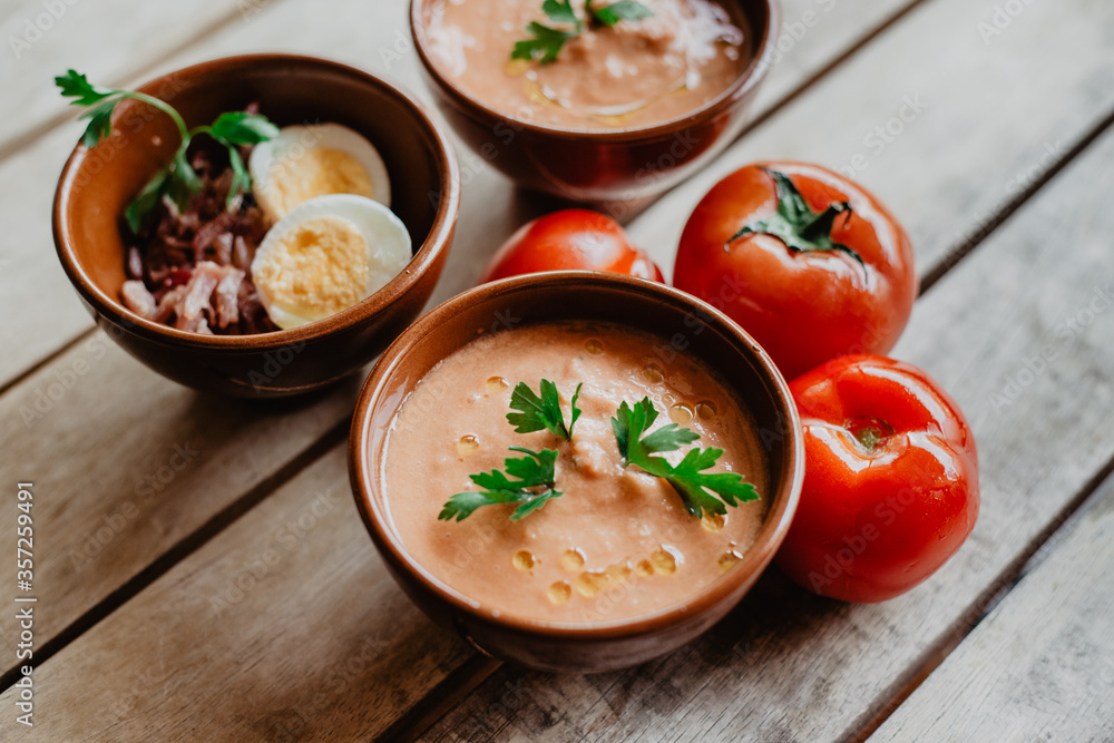 clay bowls with Andalusian gazpacho, along with some tomatoes, parsley, chopped egg, and Iberian ham clay bowls with Andalusian gazpacho, along with some tomatoes, parsley, chopped egg, and Iberian ham